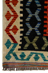 Detalle de guarda y flecos de alfombra Kilim multicolor con motivos geométricos