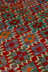 Detalle de textura de alfombra Kilim con rombos geométricos en violeta y naranja