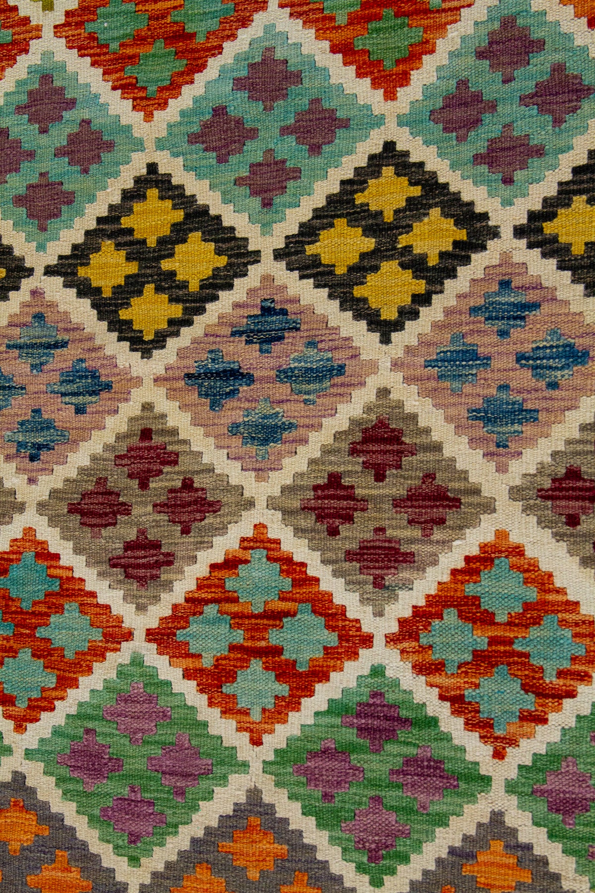 Detalle del diseño geométrico de alfombra Kilim multicolor con rombos y motivos repetitivos