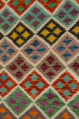 Detalle del diseño geométrico de alfombra Kilim multicolor con rombos y motivos repetitivos