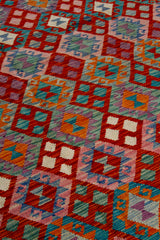 Detalle de textura de alfombra Kilim con diseño geométrico en rosa y naranja