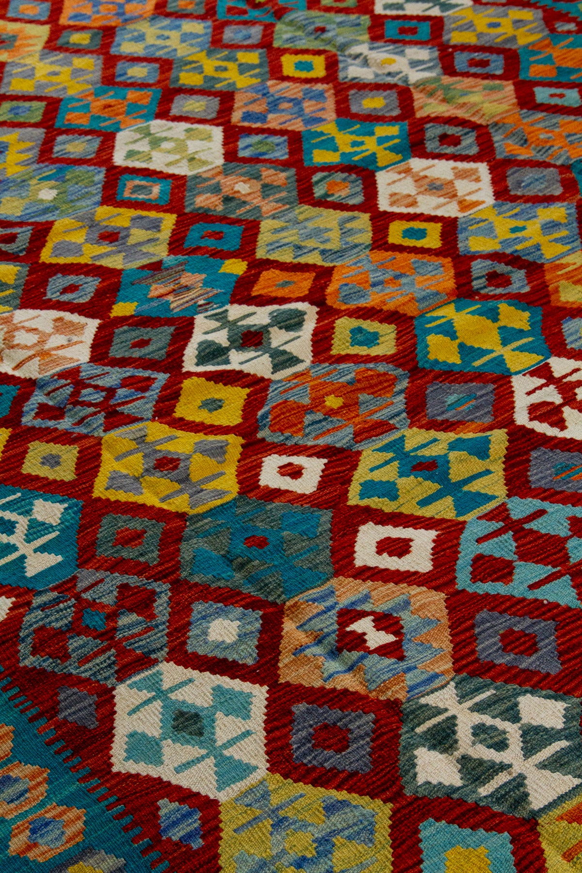 Detalle de textura de alfombra Kilim con diseño geométrico multicolor y rombos decorativos