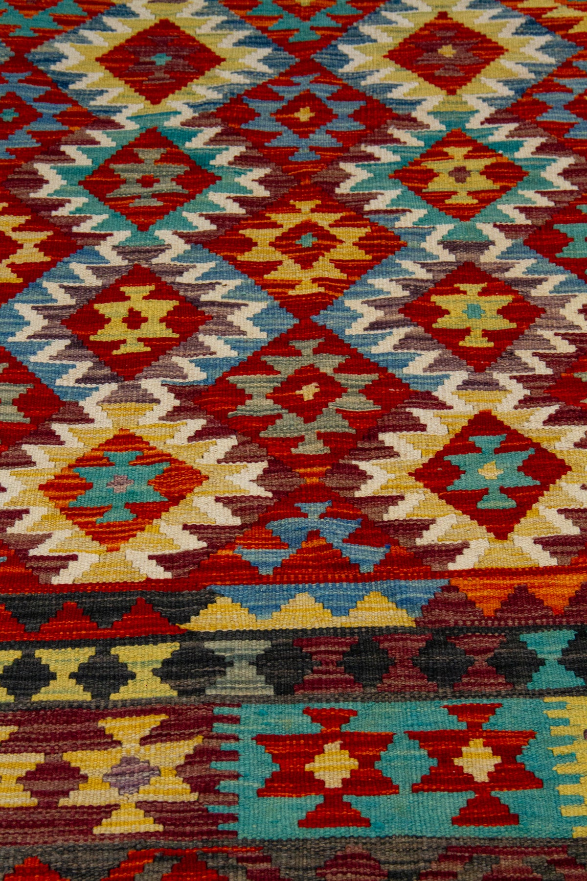 Detalle del diseño geométrico de alfombra Kilim multicolor con rombos 