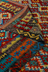 Detalle de textura y doblez de alfombra Kilim multicolor con motivos geométricos tradicionales