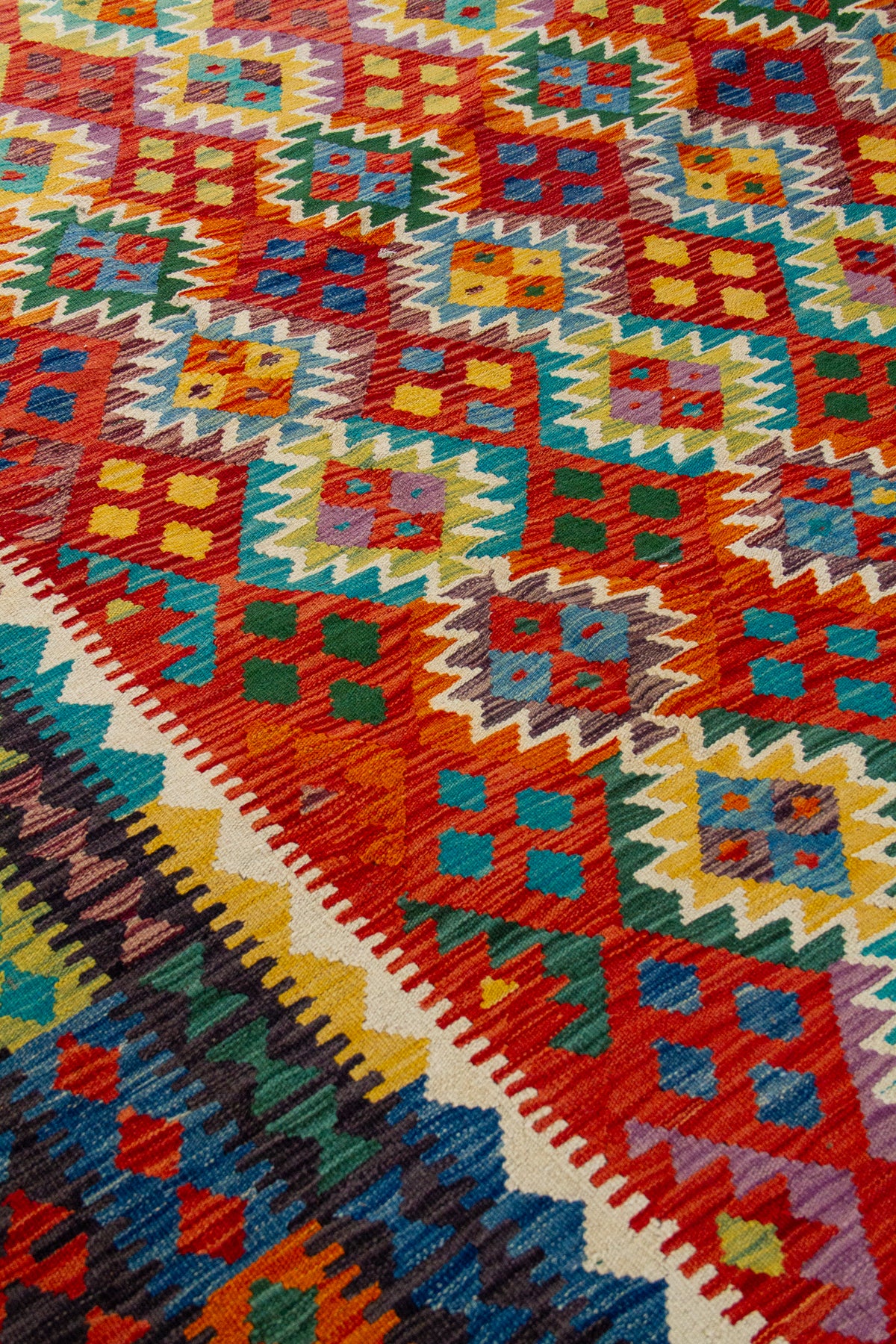 Detalle del diseño de alfombra Kilim en tonos naranja y amarillo