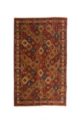 Alfombra artesanal rectangular en tonos rojo, beige, azul y marrón con diseño geométrico repetitivo y guarda decorativa clara