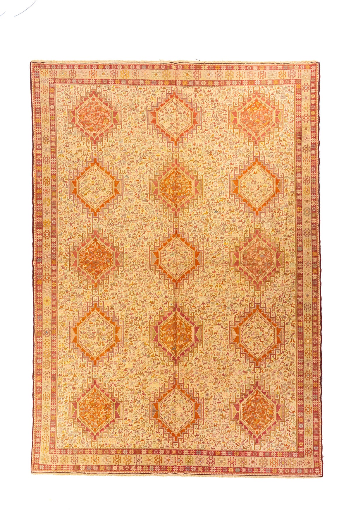 Alfombra rectangular en tonos beige y rojo con medallones geométricos y motivos tribales