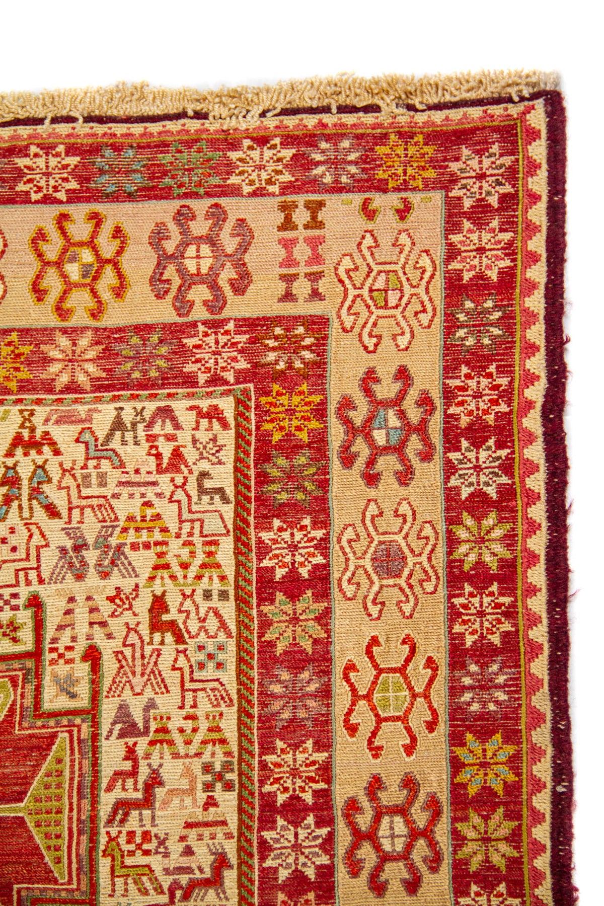 Detalle del borde de alfombra con guarda beige, rojo y pequeños motivos geométricos florales