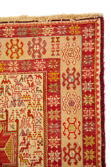 Detalle del borde de alfombra con guarda beige, rojo y pequeños motivos geométricos florales