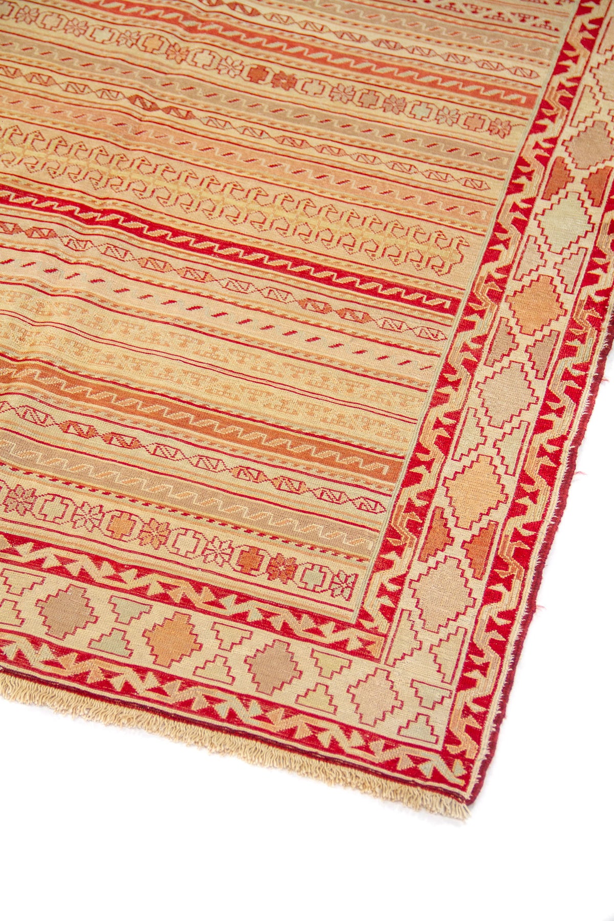 Primer plano de alfombra con diseño de líneas horizontales y guarda en tonos rojo intenso y blanco suave