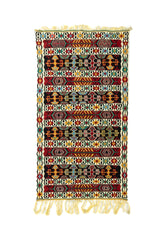 Alfombra artesanal rectangular con franjas geométricas en rojo, negro, blanco suave, verde, azul y dorado, con flecos en ambos extremos