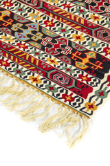 Primer plano de alfombra de estilo tribal con franjas geométricas en rojo, negro, azul claro, verde y amarillo