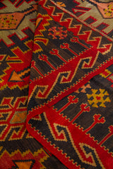 Detalle de alfombra doblada que resalta la guarda geométrica y los colores intensos del tejido artesanal.