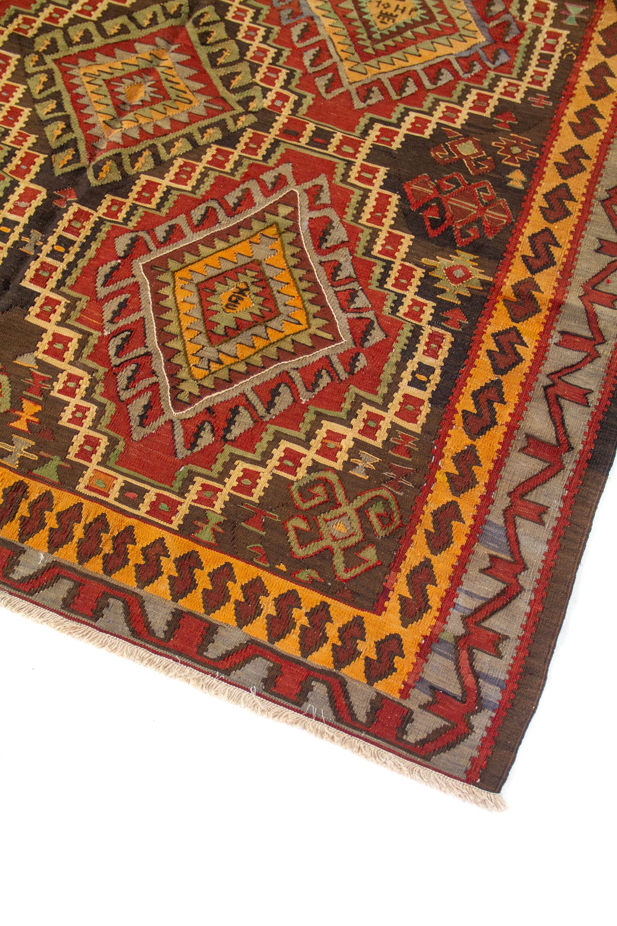Primer plano de alfombra vintage con motivos geométricos tribales, rombos centrales y guarda decorativa en rojo, dorado y marrón
