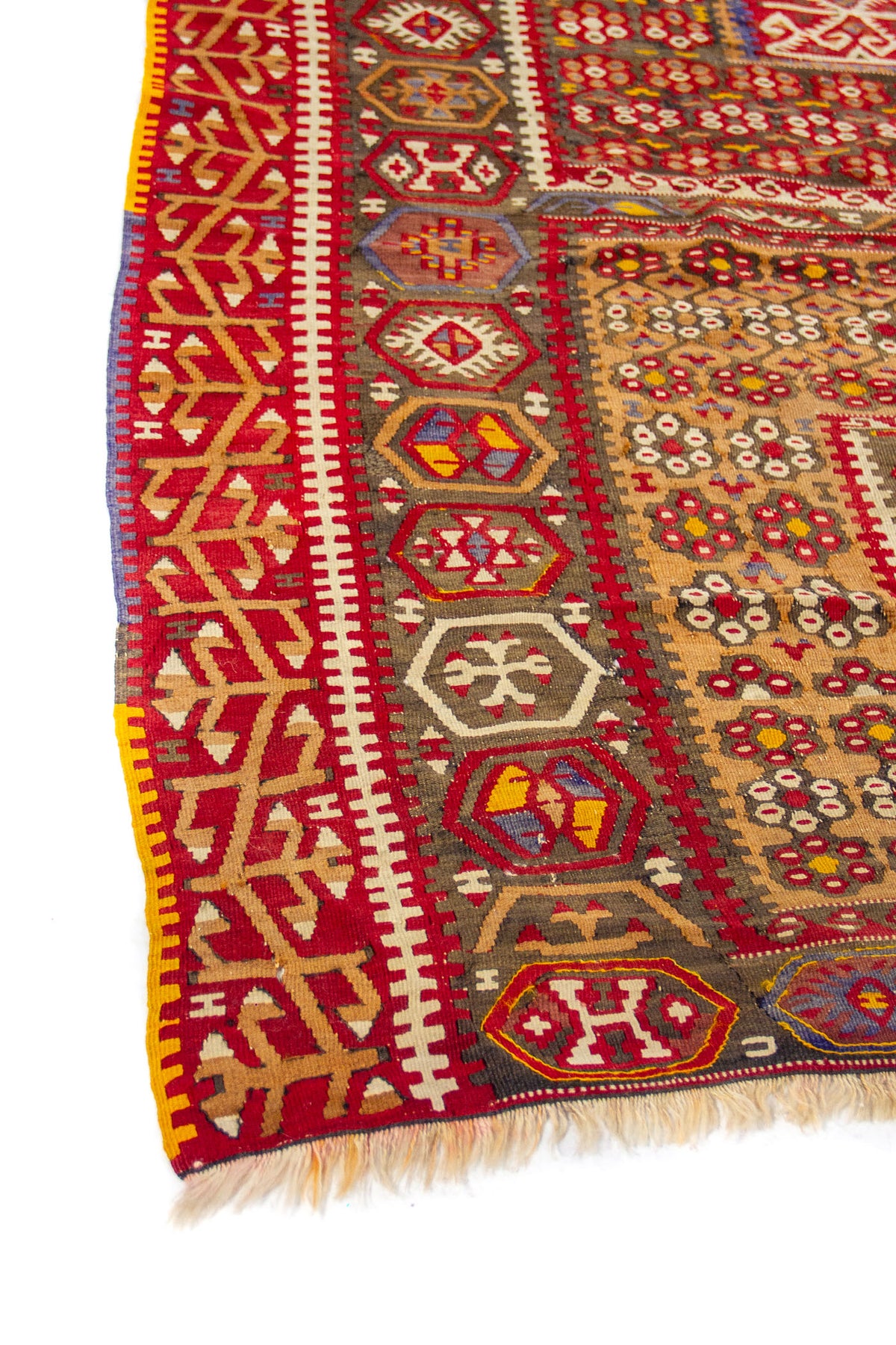 Detalle de borde de alfombra vintage con patrones geométricos en rojo, beige, gris y amarillo