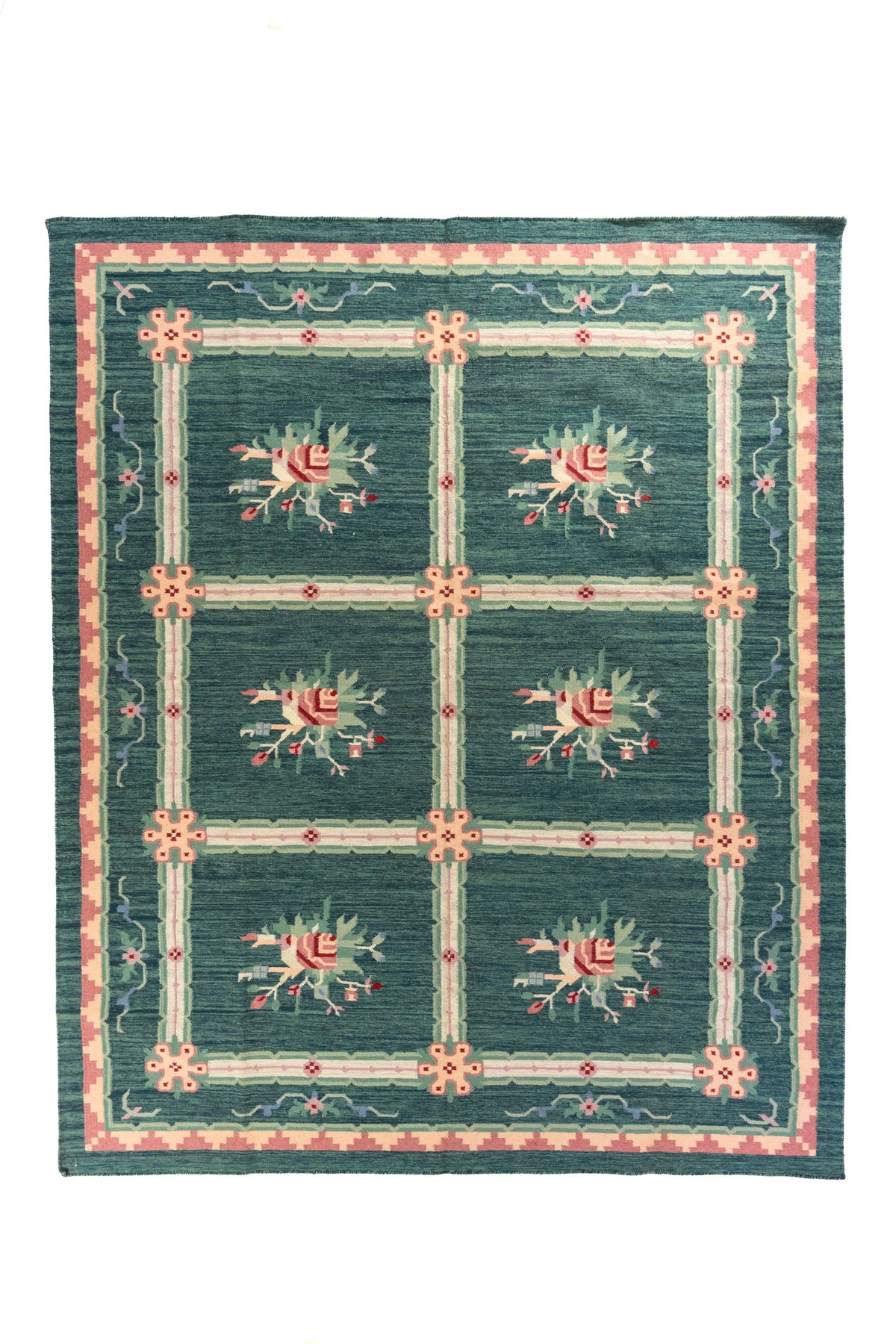 Alfombra rectangular en tono verde y azul con diseño de cuadrícula y ramilletes florales en el centro