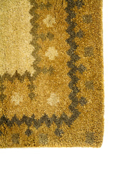 Detalle lateral de alfombra clásica en tonos cálidos con bordes geométricos y diseño de marcos concéntricos