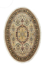 Alfombra oriental ovalada en tonos beige y blanco suave con medallón central ornamental y guarda negra con motivos florales