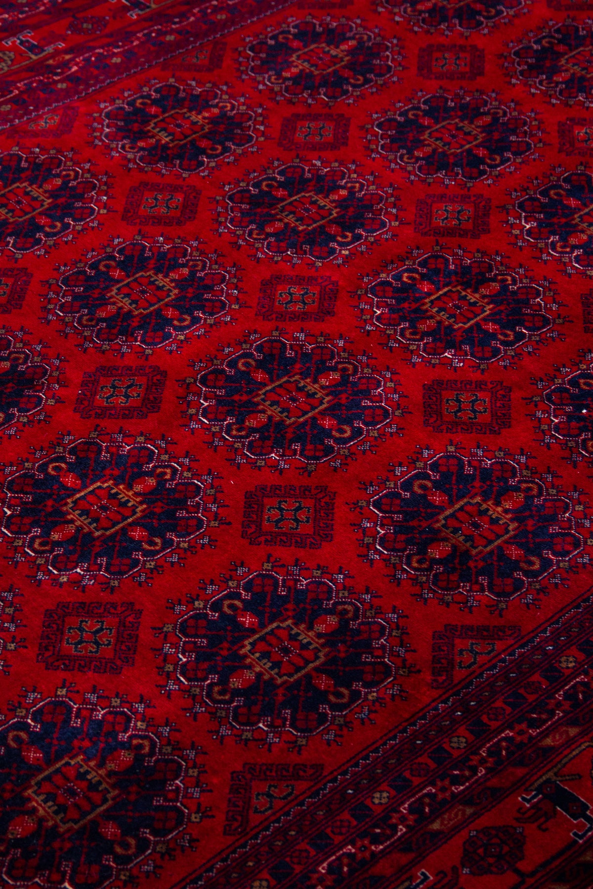 Detalle de textura de alfombra persa roja con medallones geométricos repetitivos