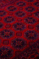 Detalle de textura de alfombra persa roja con medallones geométricos repetitivos
