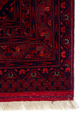 Detalle de guarda y flecos de alfombra Persa Afgan roja con motivos tradicionales