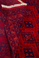Detalle de textura, reverso y diseño de alfombra Persa Afgan roja con flecos blancos