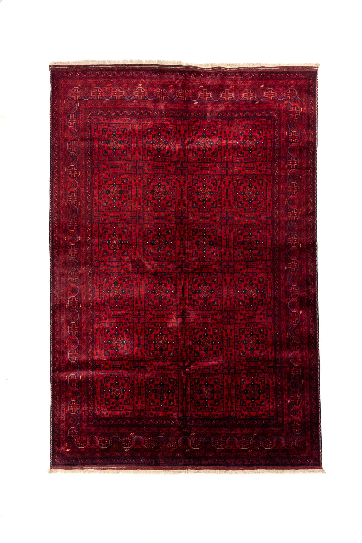 Alfombra oriental rectangular en tonos rojo y azul oscuro con diseño geométrico repetitivo y flecos beige en los extremos.