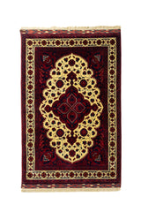 Alfombra clásica de inspiración oriental con fondo rojo oscuro, gran medallón central en tono amarillo claro y detalles florales en azul marino, rojo y beige.