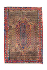 Alfombra oriental rectangular en tonos marrón, rojo y azul con gran medallón geométrico central y guarda decorativa en rojo intenso