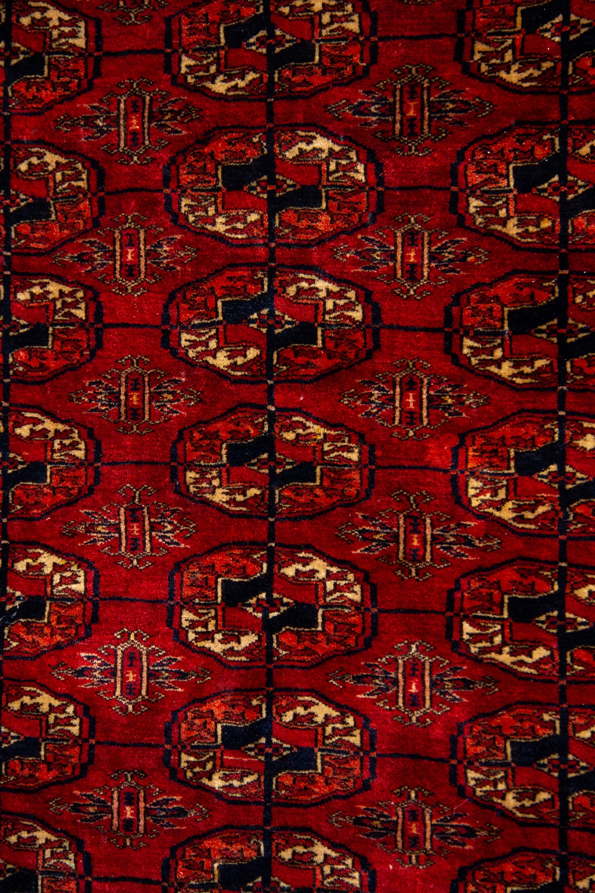 Detalle del diseño central geométrico en alfombra persa Bukara color rojo