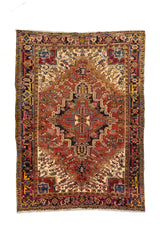Alfombra oriental rectangular en tonos rojo, beige, azul y negro con gran medallón geométrico central y guarda tribal decorativa