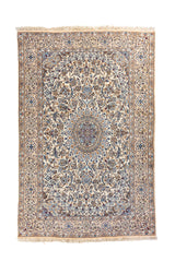 Alfombra rectangular de estilo oriental en tonos blanco suave, celeste, azul y beige, con medallón central floral y guarda decorativa detallada.