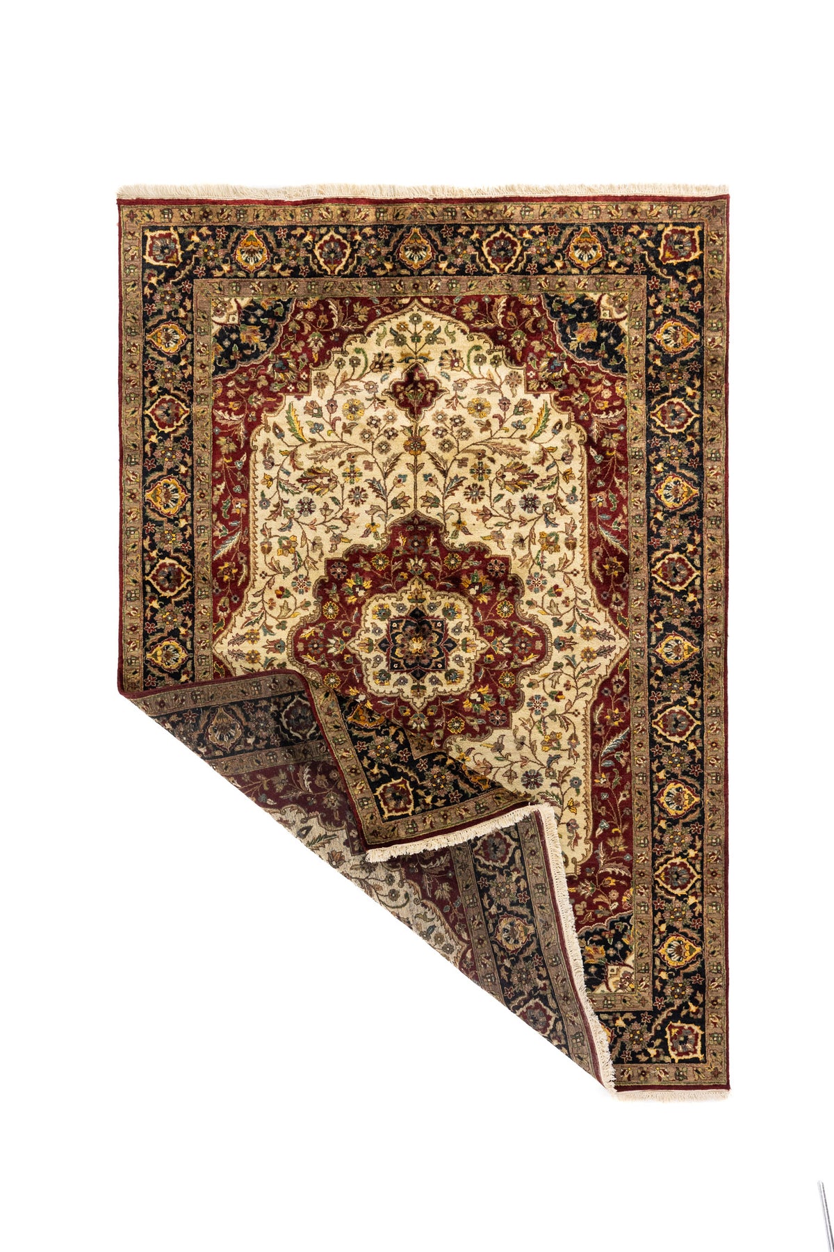 Alfombra oriental en tonos blanco suave y rojo oscuro con una esquina doblada, mostrando el reverso del tejido y su diseño floral clásico.