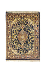 Alfombra oriental rectangular en tonos azul marino, beige y café con medallón floral central y borde decorativo clásico