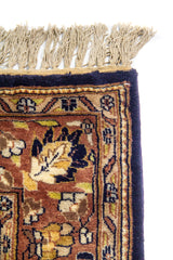 Detalle de borde y flecos de alfombra oriental con motivos florales pequeños y terminación en azul oscuro