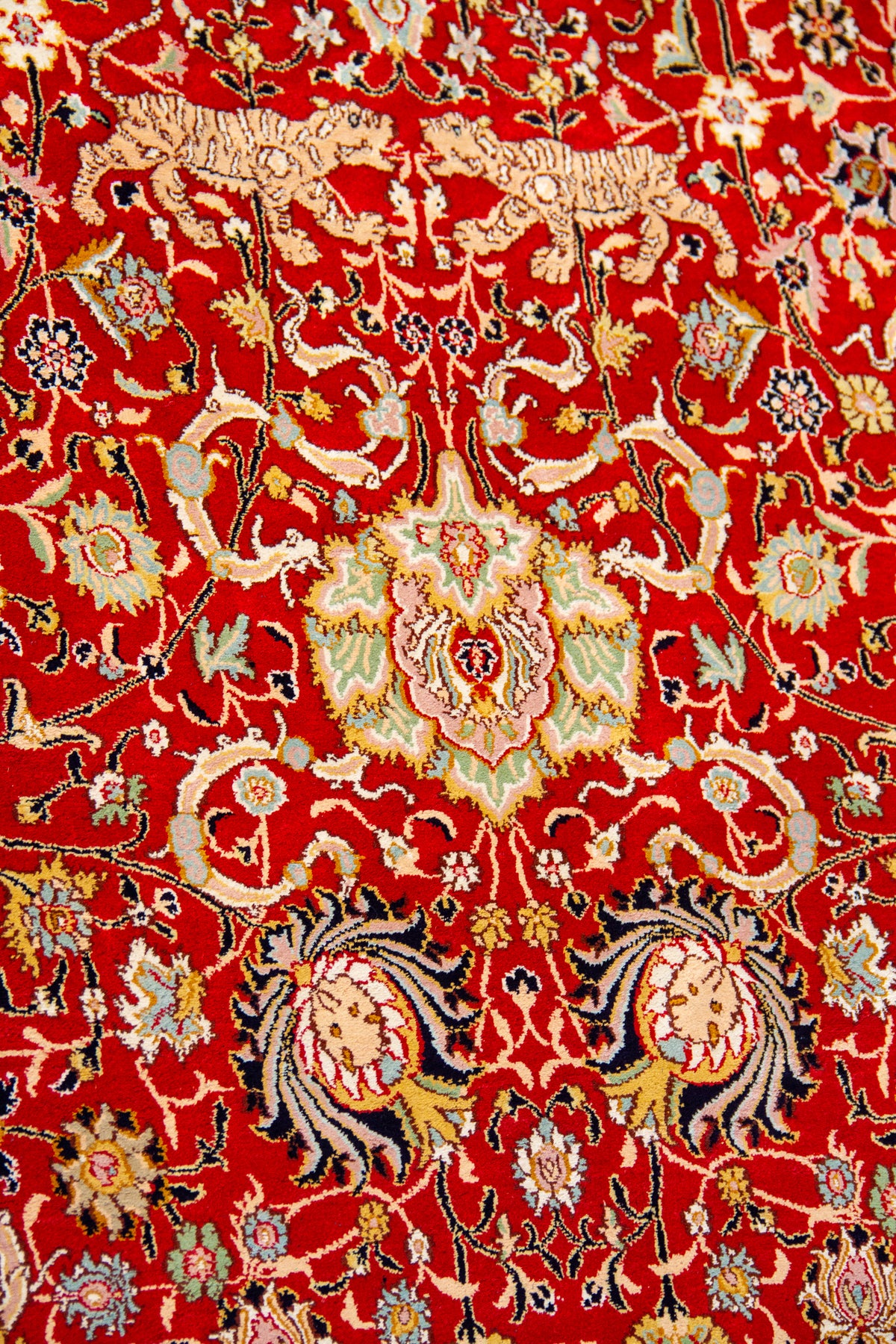 Detalle del diseño floral de alfombra persa roja con motivos ornamentales y figuras animales