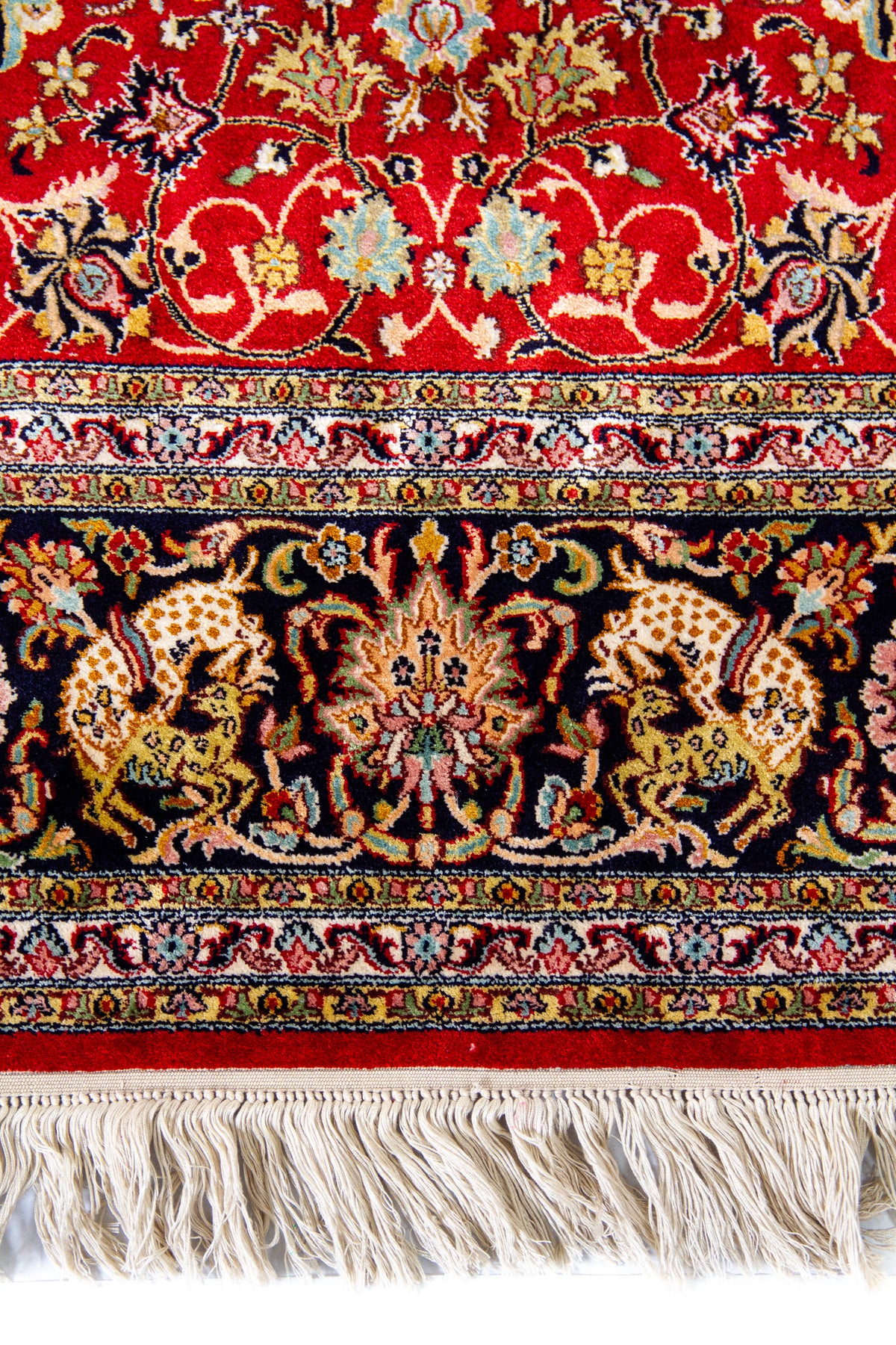 Detalle de guarda y flecos de alfombra Persa Ispahan Seda en tonos rojo, negro y blanco