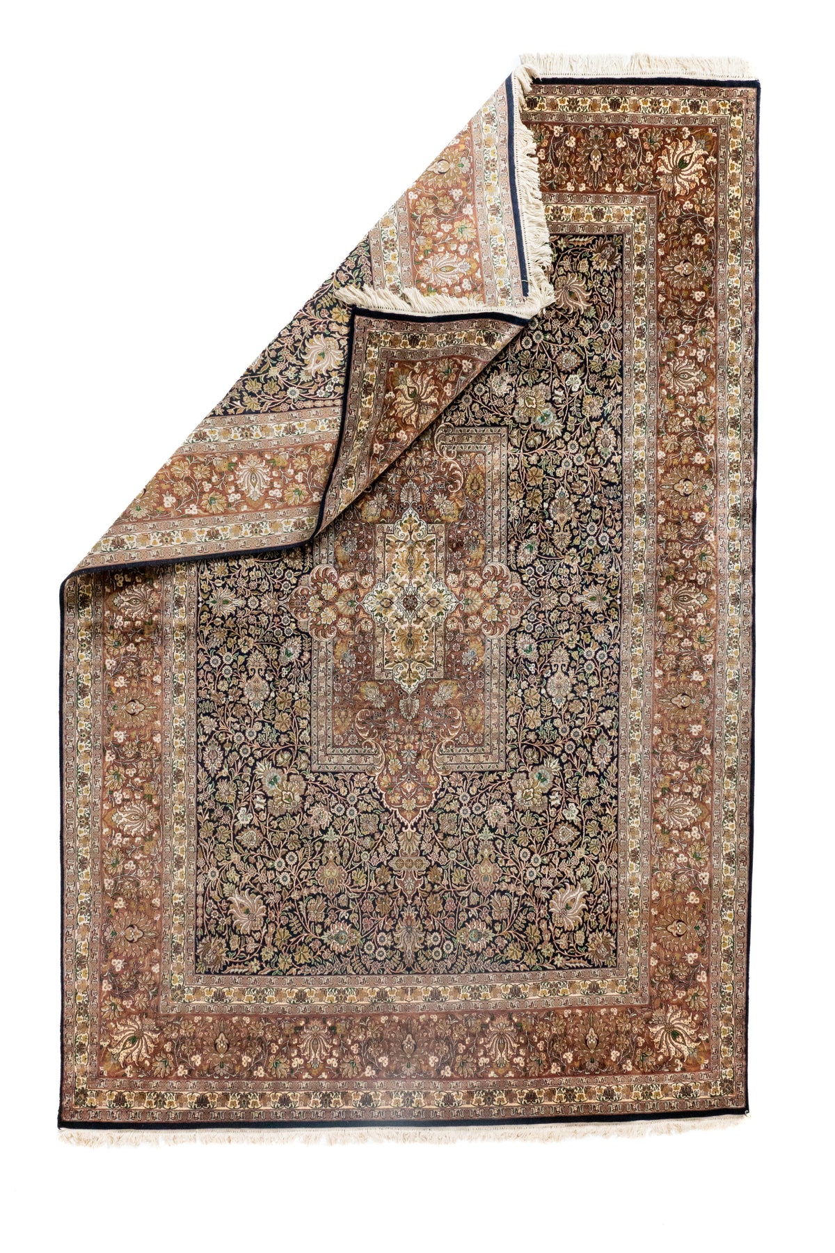 Alfombra Persa Ispahan Seda con esquina doblada mostrando reverso, flecos y guarda floral