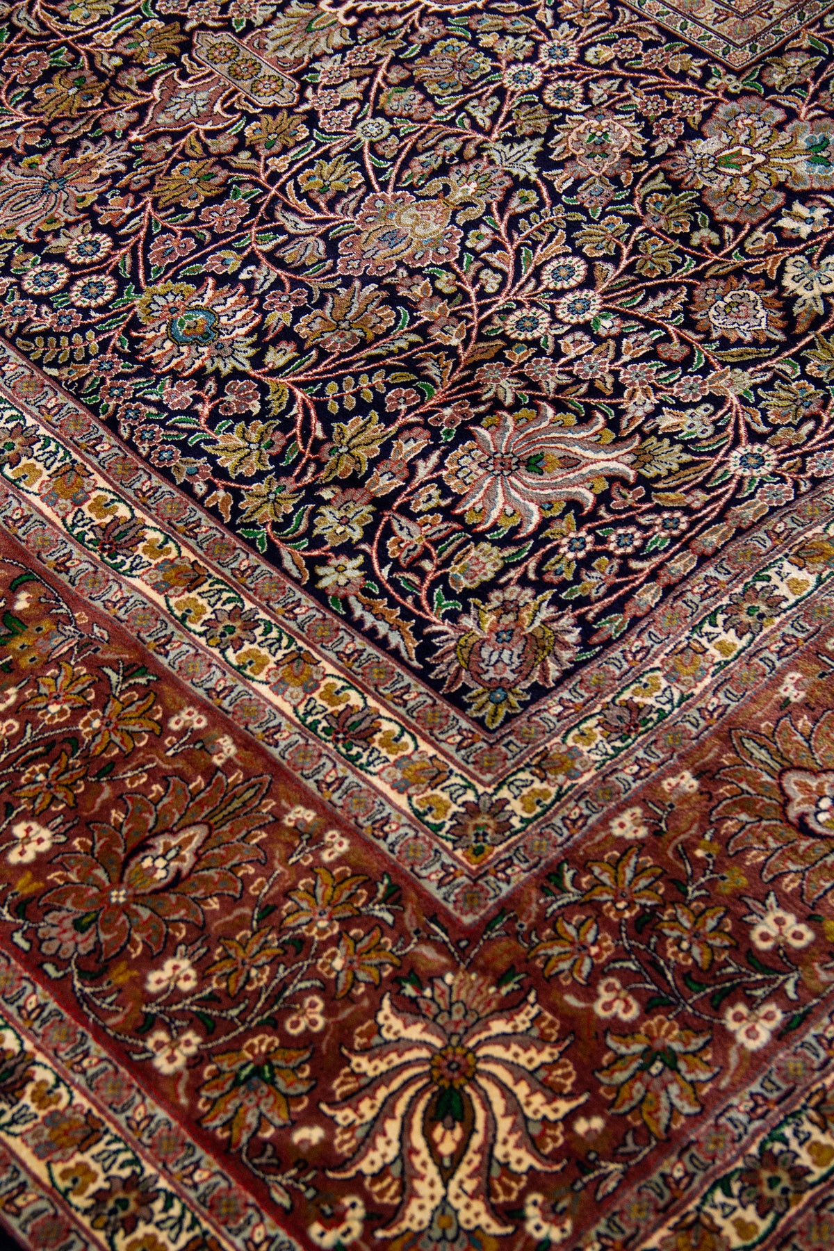 Detalle del diseño floral de alfombra Persa Ispahan Seda con arabescos y tonos cálidos