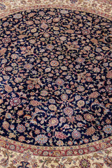 Detalle del diseño floral central de alfombra persa Ispahan Seda en azul oscuro