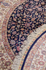Detalle de textura y flecos de alfombra persa redonda con diseño floral clásico