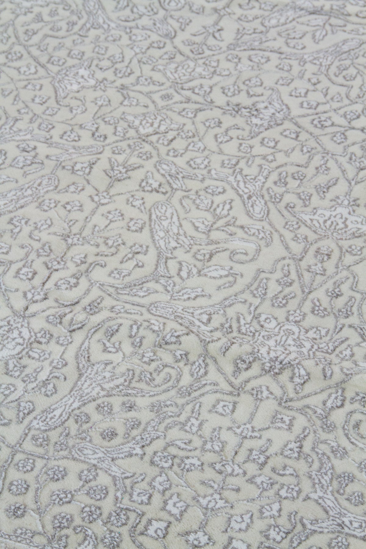 Detalle del diseño floral de alfombra Persa Nain en tonos beige y gris