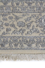 Detalle de textura y diseño floral de alfombra Persa Nain en tonos beige y gris