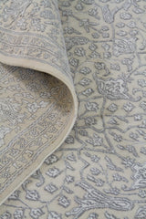 Detalle de doblez y arabescos florales de alfombra Persa Nain beige