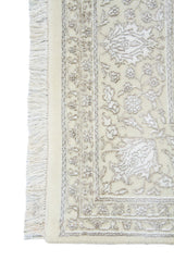 Detalle de guarda y flecos de alfombra Persa Nain beige con motivos florales