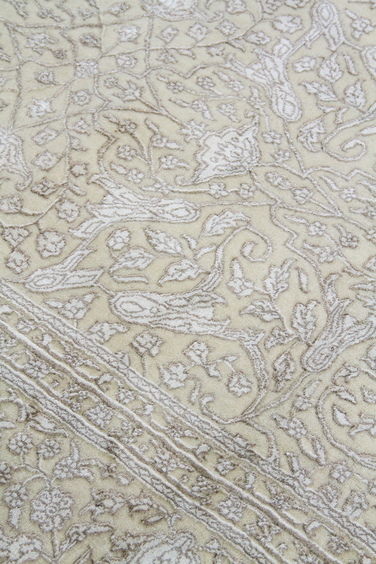 Detalle de textura y diseño floral de alfombra Persa Nain en beige y blanco