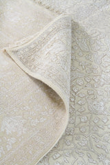 Detalle de doblez y arabescos de alfombra Persa Nain beige de estilo clásico