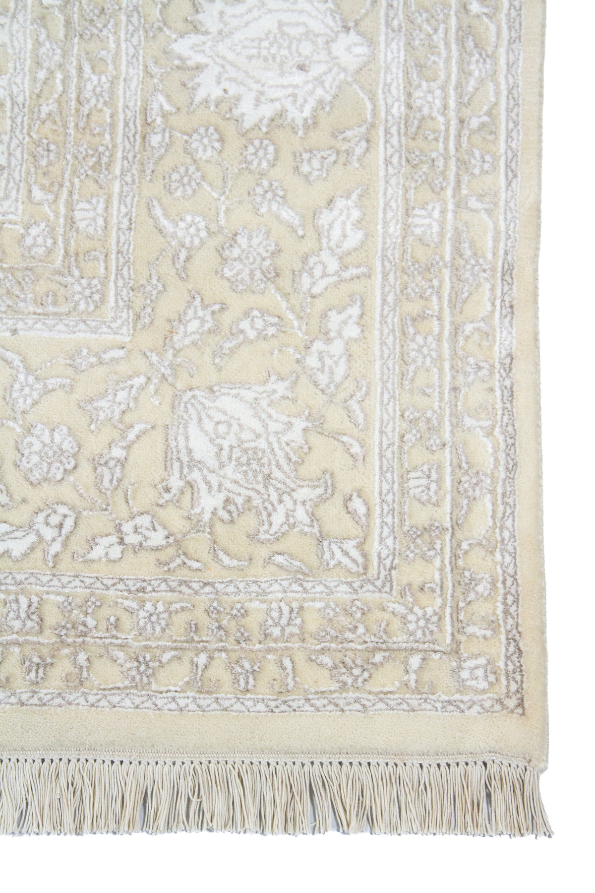 Detalle de guarda, flecos y motivos florales de alfombra Persa Nain beige