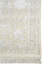 Detalle de guarda, flecos y motivos florales de alfombra Persa Nain beige