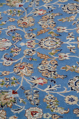 Detalle de textura de alfombra persa celeste con motivos florales y arabescos decorativos
